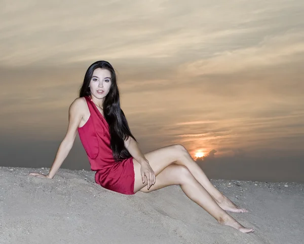 日没で、砂漠にポーズをとって赤いドレスでかわいい女性 — ストック写真