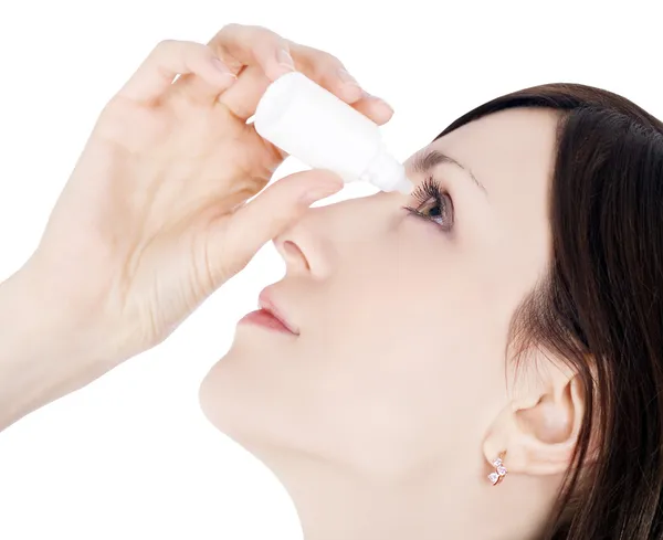Frau tropft Auge mit Augentropfen Stockbild