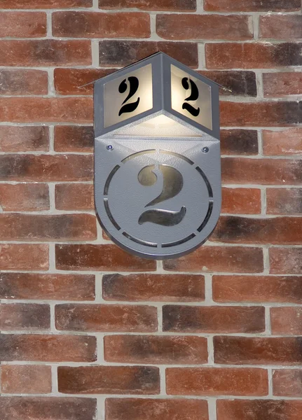 Le numéro deux (2) sur un mur de briques . — Photo