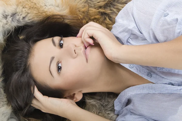 Красивая молодая женщина, лежащая в мехе — стоковое фото