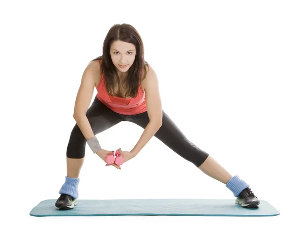 Attraente giovane donna con manubri fitness in stretching — Foto Stock