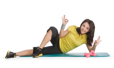 Attractive young female with fitness dumbbells in sport center clipart