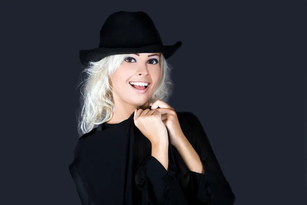 Blonde fashion woman portrait wearing black hat over dark — Stock Photo, Image