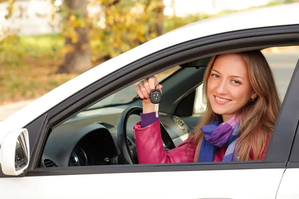 Mulher mostrando a chave de seu carro novo — Fotografia de Stock