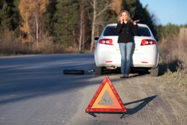 Jovem mulher em pé perto de seu carro danificado e pedindo ajuda — Fotografia de Stock