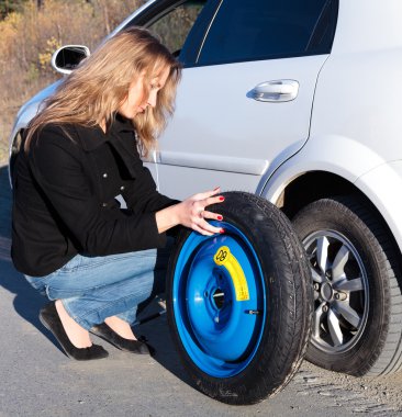 Young woman and the car with deflated wheel clipart