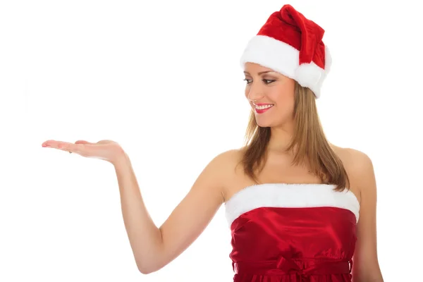 Pretty girl wearing red Christmas hat, holding a hand palm up. — Stock Photo, Image