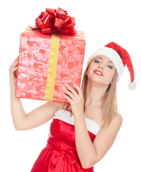Cheerful santa helper girl with big gift box on her shoulder — Zdjęcie stockowe