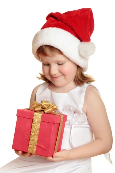 Baby Mädchen mit Weihnachtsmütze hält ihr Weihnachtsgeschenk — Stockfoto
