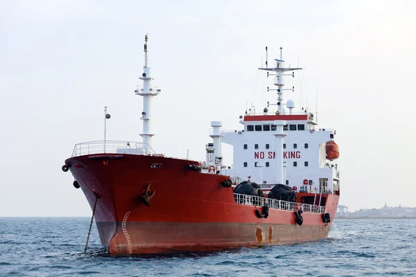 Красный танкер на якоре рядом с портом . — стоковое фото