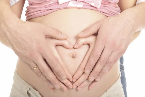Hart-vormige handen van zwangere vrouw en haar echtgenoot — Stockfoto