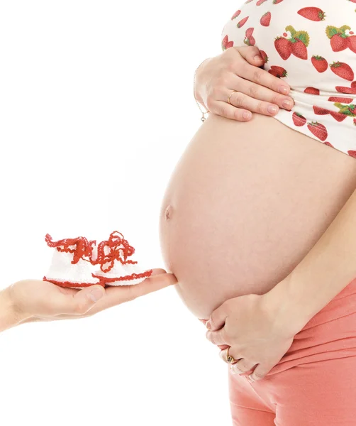 Pregnant woman and her husband's palm with little boots — Stock Photo, Image