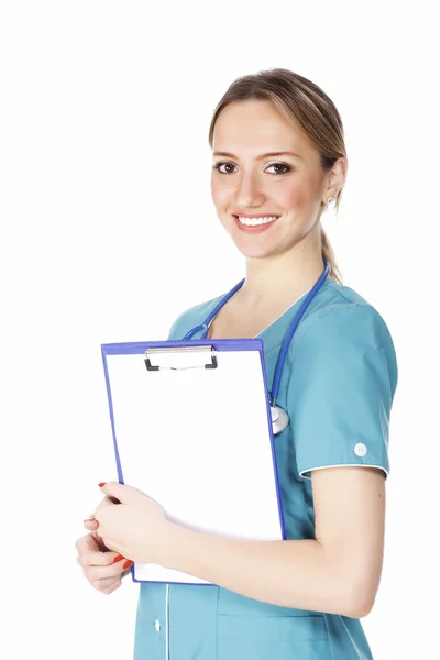 Smiling female doctor holding a clipboard against white — Stock Photo, Image
