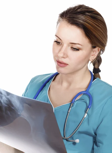 Vrouwelijke arts in de groene uniforme kijkend naar de x-ray afbeelding. — Stockfoto