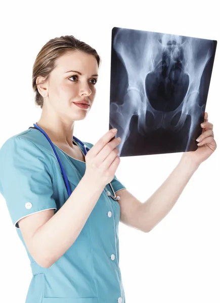 Vrouwelijke arts in de groene uniforme kijkend naar de x-ray afbeelding. — Stockfoto