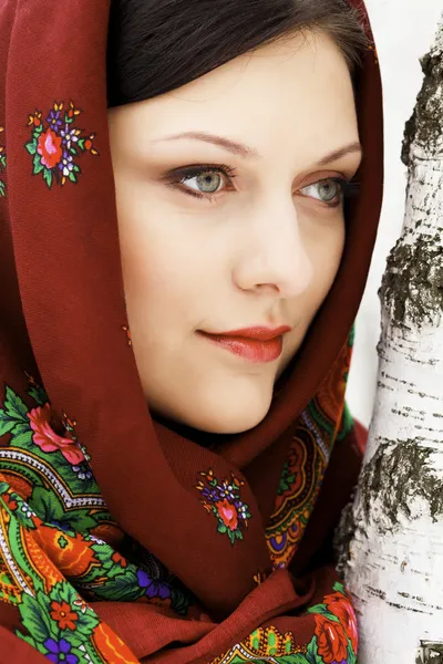 Hermosa mujer rusa en chal de pie junto al abedul — Foto de Stock