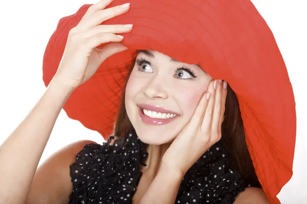 Behoorlijk opgewonden vrouw in de rode hoed poseren tegen witte achtergrond. — Stockfoto