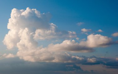 White fluffy cumulus clouds on a blue sky clipart