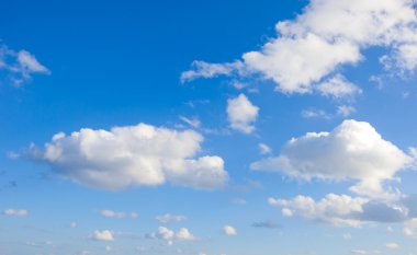 White fluffy cumulus clouds on a blue sky clipart