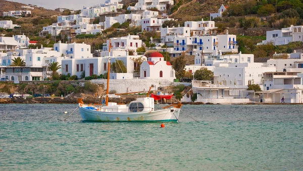 Fishing boat in the harbor of Mykonos against the white buildings of the is — Stock Photo, Image