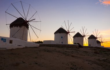 A number of famous windmills on the island of Mykonos at sunset. clipart