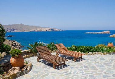 Garden with sun loungers on the background of the sea. Mykonos. Greece. clipart