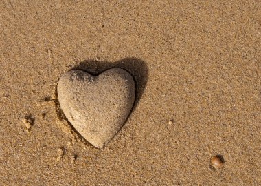 Heart shape of the sand near the sea - a symbol of love clipart