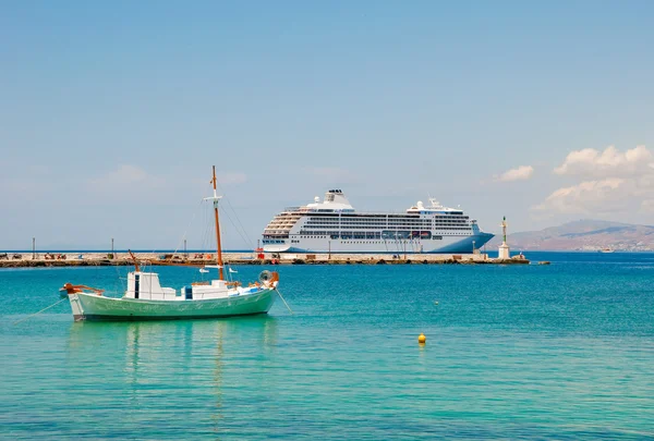 Een kleine vissersboot en grote cruise schip in de Middellandse Zee in de buurt van de is — Stockfoto