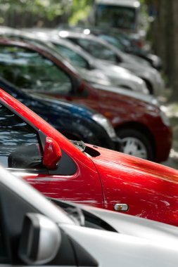 Row of parking cars, selective focus on the red one clipart