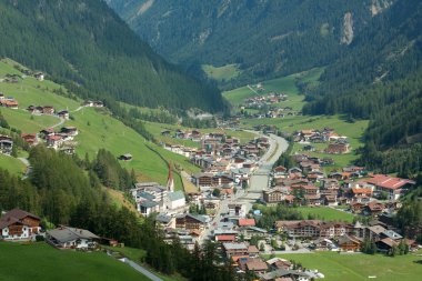 Green alpine valley with nice small town and river clipart