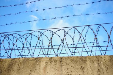 Prison wall on blue sky background clipart