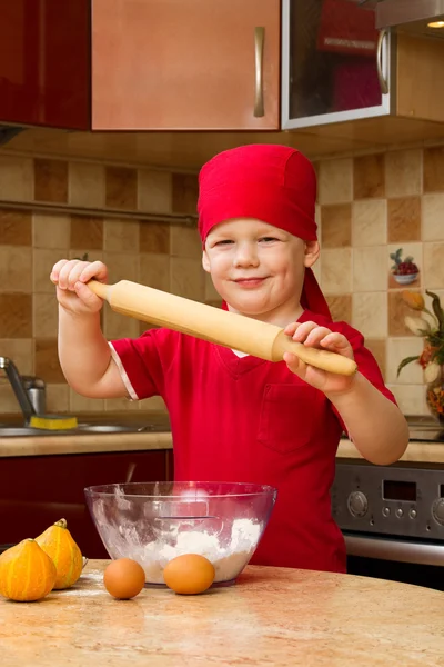 Pieni poika keittiössä leivontaan piirakka — kuvapankkivalokuva