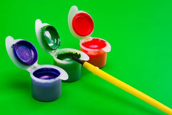 Three Cans Paint Green Red Blue Paintbrush Green Background — Stock Photo, Image