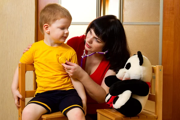 Frau untersucht mit Stethoskop Kind — Stockfoto