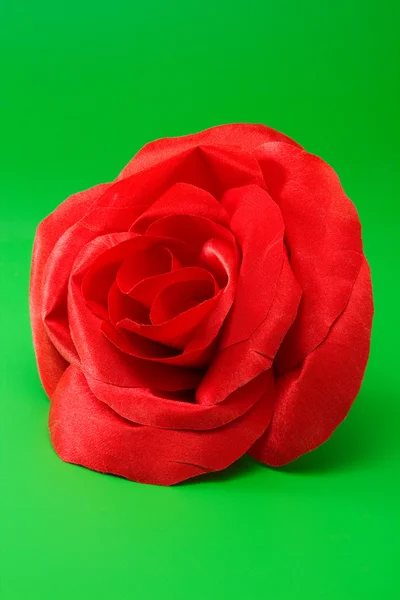 Decoratieve rode zijde rose op groen — Stockfoto