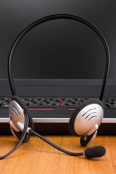 stock image Headset and laptop on office desk