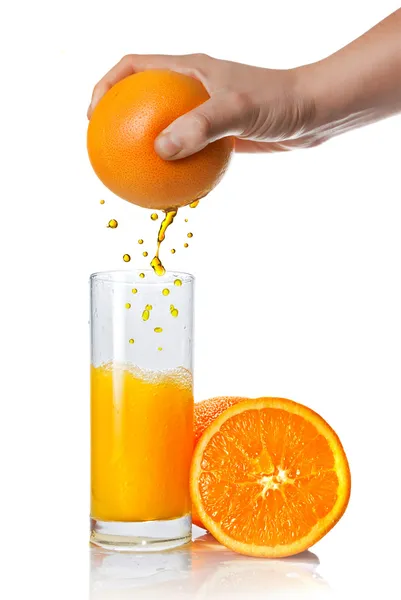 Spremitura succo d'arancia versando in vetro isolato su bianco — Foto Stock