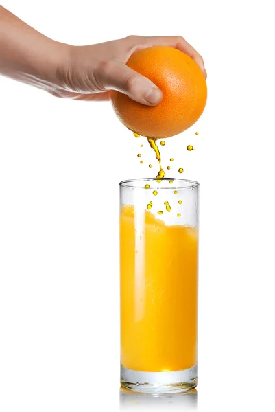 Squeezing orange juice pouring into glass isolated on white — Stock Photo, Image