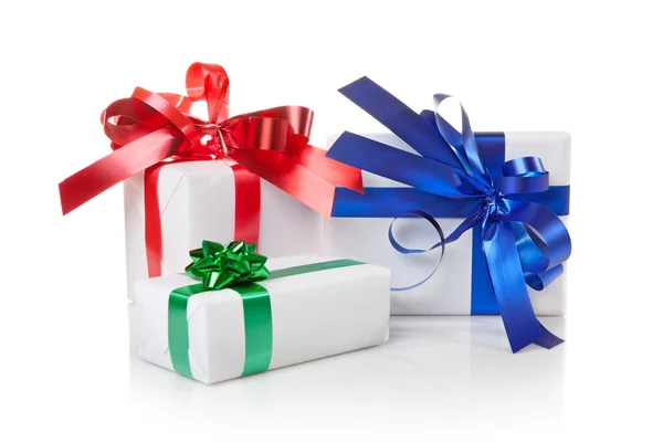Weihnachtsgeschenke mit farbigen Bändern isoliert auf weiß — Stockfoto
