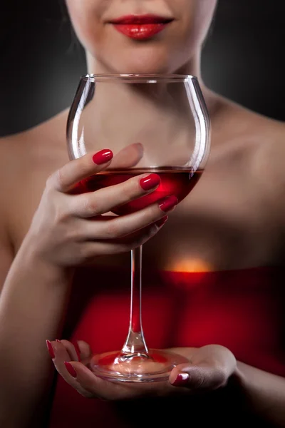 Woman in red holding wine glass and smiles — Stock Photo, Image