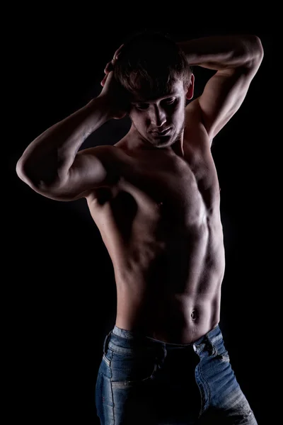 Poserar naken muskulös man på svart — Stockfoto