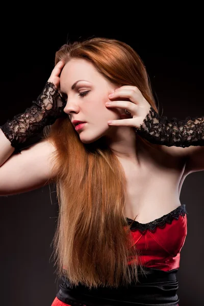 Ελκυστική σέξι γυναίκα με κόκκινο μακριά μαλλιά σε μαύρο — Φωτογραφία Αρχείου
