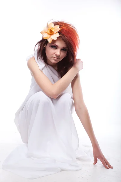 Portret van mooie vrouw met voorjaar bloem in haren op wit — Stockfoto