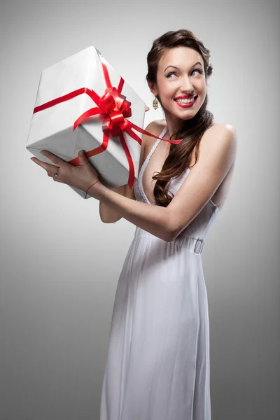 Unga förvånad leende kvinna med gåva — Stockfoto