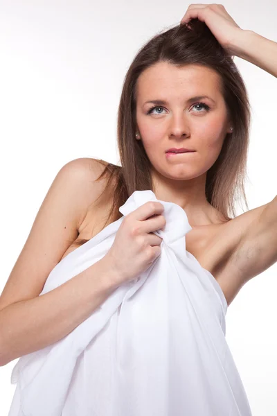 Привлекательная женщина, покрытая белой тканью на белом — стоковое фото