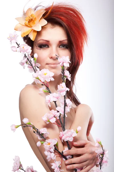 Portrait of beautiful naked woman with spring flower in hair on white — Stock Photo, Image
