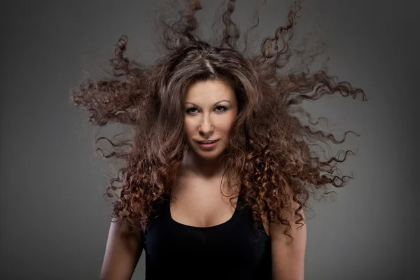 Porträt einer schönen Frau mit lockigem Haar in der Luft — Stockfoto