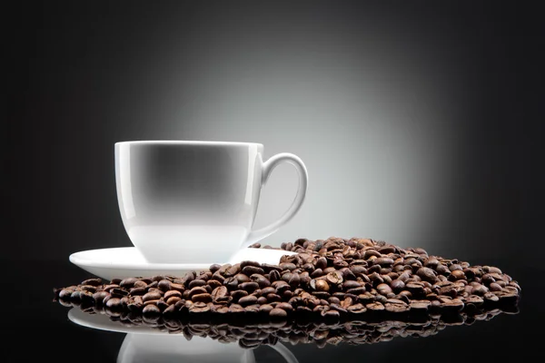 Vit kopp med kaffe bönor på svart — Stockfoto