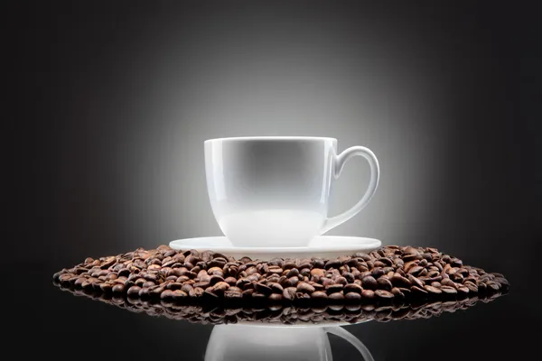 Siyah kahve çekirdekleri ile beyaz fincan — Stok fotoğraf