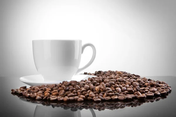 Vit kopp med kaffe bönor på vit — Stockfoto